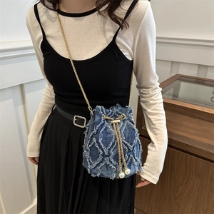 Quilted denim bucket bag with pearl drawstring and golden chain strap on model