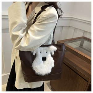 Detail van de grote bruine shopper met witte pluche hond patch op de schoudertas