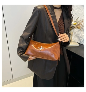 Detail of vintage brown oil-wax leather shoulder bag with silver star metal accent