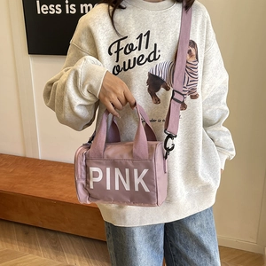 Sac cylindrique en nylon rose avec lettrage PINK et bandoulière réglable