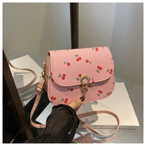 Detailed shot of pink crossbody bag with cherry prints and golden droplet metal clasp