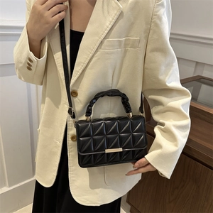 Chic black quilted square shoulder bag with gold metal buckle shown on a model