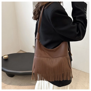 Detail view of deep brown hobo bag with long hanging fringe and litchi texture leather