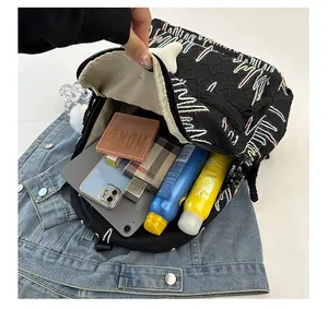 Detail showing the large storage capacity of a black backpack with colorful wave embroidery