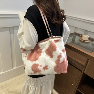 Pink cow print plush tote bag for women with dual shoulder straps and fuzzy texture