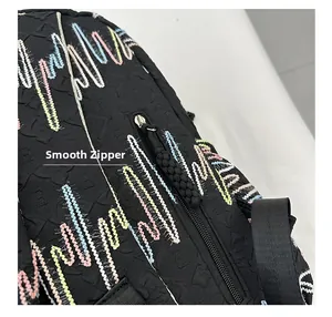 Detailed macro view of the smooth zipper and colorful embroidery on a black backpack
