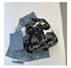 Detail of black quilted backpack with wave embroidery and cute plush star charms