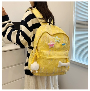 Close-up of yellow backpack featuring textured jacquard fabric and star smiley patches