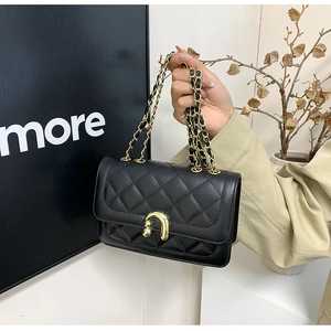 Detailed close-up of quilted leather texture and gold horseshoe buckle on crossbody bag