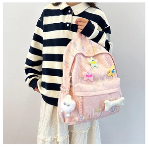 Pink quilted school backpack with rainbow embroidery and cute star plush charms