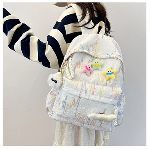 Detail of white jacquard backpack with colorful star charms and soft plush pendant