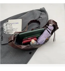 Top-down view of spacious interior of dark brown leather hobo bag holding daily essentials