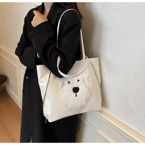 Close-up of white PU leather tote bag with cute plush dog patch and side zippers