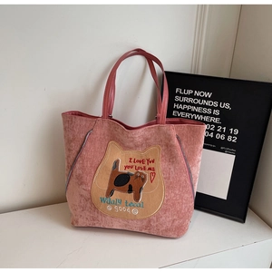Detail of pink corduroy tote bag featuring a cute cat patch and silver zipper accents