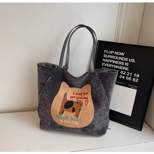 Detail of gray corduroy tote bag featuring a cat patch and refined embroidery finish