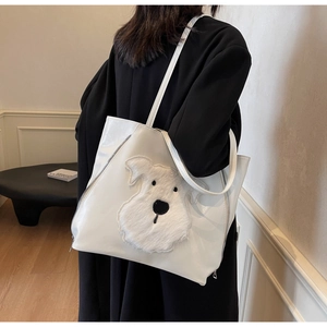 Close-up of a white tote bag featuring a cute plush Schnauzer patch and zipper detail