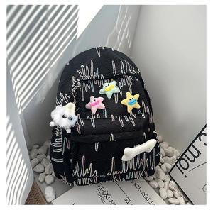 Detail view of black quilted backpack with wave embroidery and colorful star patches