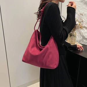 Minimalist large magenta suede tote bag with knotted strap detail shown on model