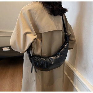 Detailed back view of a black pleated croissant bag with wide shoulder strap styling