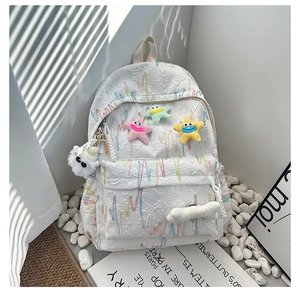 Close-up of white embossed fabric backpack with colorful star embroidery and plush charm