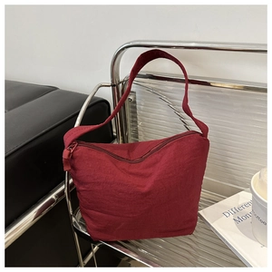 Detailed shot of a burgundy hobo bucket bag on a metal rack in a modern interior