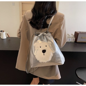 Detail of silver metallic backpack with cute plush puppy patch in a modern interior