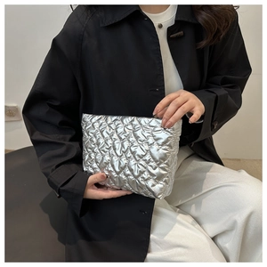 Detail of silver quilted handbag featuring heart-shaped stitching and metallic texture