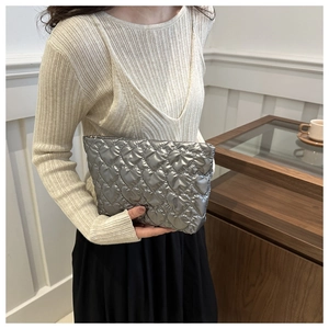 Close-up of silver metallic clutch with heart quilting and secure top zipper closure