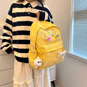 Bright yellow school backpack with textured embroidery and cute plush star pendants