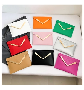 Detailed flat lay of nine colorful envelope clutch bags with V-shaped metal trim detail