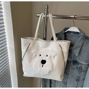 Detail of white PU leather tote bag featuring a cute plush dog patch and side zippers