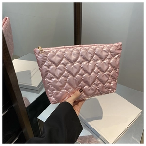 Detail of pink heart quilted satin makeup bag with golden zipper for women