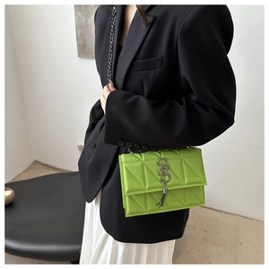 Gros plan d'un sac bandoulière vert fluo matelassé avec pampille sur un mannequin