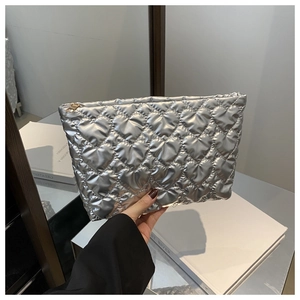 Detail of silver metallic purse with heart quilting and gold zipper closure