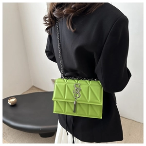 Détail du sac bandoulière vert fluo matelassé avec boucle à franges et chaîne argentée