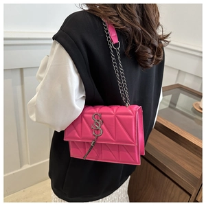Détail du sac bandoulière matelassé rouge rose avec chaîne argentée et logo métal
