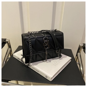 Détail du sac bandoulière noir matelassé avec logo S argenté et chaîne élégante