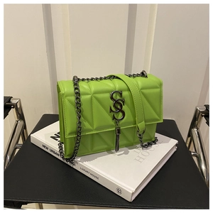 Détail du sac bandoulière matelassé vert fluo avec chaîne en métal et pompon