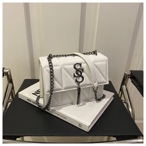 Détail du sac bandoulière blanc matelassé avec logo S en métal et pompon chic