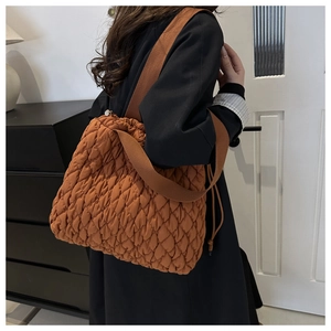 Detailed view of caramel quilted shoulder bag with drawstring and rhombus texture
