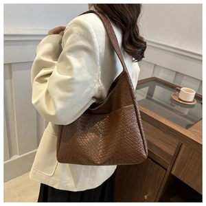 Close-up of deep brown woven leather tote bag with thick shoulder strap for women