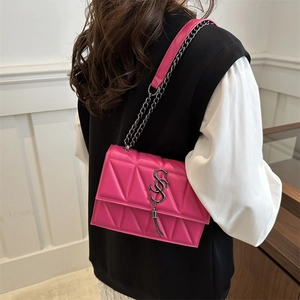 Sac bandoulière matelassé magenta avec coutures triangulaires et pompon en métal argenté