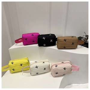 Quilted pouch assortment in six colors featuring delicate embroidered bow patterns