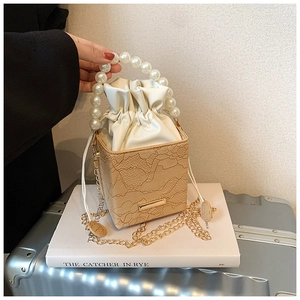 Detail der quadratischen Handtasche aus aprikosenfarbener Spitze mit Perlengriff