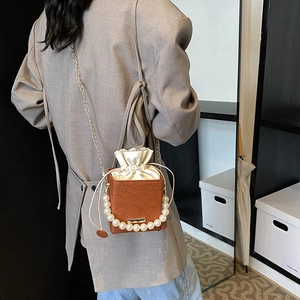 Braune Box-Tasche mit Spitzenmuster, Perlengriff und goldener Kette als Umhängetasche