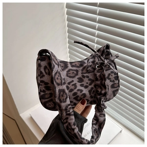 Detailed view of leopard print plush hobo bag with bow tie strap and pleated texture