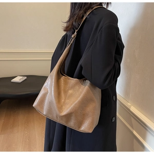 Minimalist hobo shoulder bag in brown faux leather shown on model for office wear