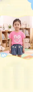Dettaglio ricamo coniglietto e accenti floreali su t-shirt rosa e pantaloncini denim