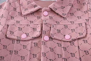 Macro shot of pink corduroy girls' jacket with letter B pattern and soft textures
