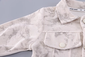 Detail of baby corduroy jacket with marble print showing lapel and textured fabric